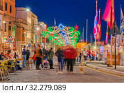 Defocused crowd of people during Christmas fair an old town street with colorful Christmas lights (2018 год). Редакционное фото, фотограф Kira_Yan / Фотобанк Лори