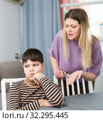 Mother and offended son arguing in domestic interior. Стоковое фото, фотограф Яков Филимонов / Фотобанк Лори