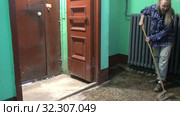 A young woman in blue jeans and a cage shirt swings and washes the floor on a staircase next to an elevator in a Stalinist-built apartment building, Cleaning public spaces by a labor immigrant cleane. Стоковое видео, видеограф Куликов Константин / Фотобанк Лори