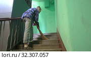 A young woman in blue jeans and a cage shirt swings and washes the floor on a staircase next to an elevator in a Stalinist-built apartment building, Cleaning public spaces by a labor immigrant cleane. Стоковое видео, видеограф Куликов Константин / Фотобанк Лори