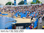 Visitors sit on grandstand and watch the show with big orca whale. Orca show with killer whales is in the Loro Park. The Loro Parque is the largest zoo in Europe. Puerto de la Cruz, Tenerife, Spain (2016 год). Редакционное фото, фотограф Кекяляйнен Андрей / Фотобанк Лори