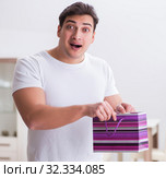 The young man with gift bag at home preparing suprise for wife. Стоковое фото, фотограф Elnur / Фотобанк Лори