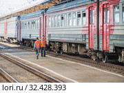 Осмотрщики (боковики) вагонов осматривают электропоезд (2015 год). Редакционное фото, фотограф Алёшина Оксана / Фотобанк Лори