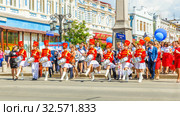 Russia, Samara, June 2017: beautiful, smart young drummers are marching in a procession dedicated to school leavers on Leningradskaya Street on a sunny summer day. Text in Russian: Kirovsky district. Редакционное фото, фотограф Акиньшин Владимир / Фотобанк Лори