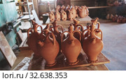 Various handmade utensils from baked clay on floor and on racks in pottery workshop. Стоковое видео, видеограф Яков Филимонов / Фотобанк Лори