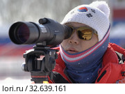 Coach of South Korea biathlon team watches biathletes in monocle at shooting range of biathlon arena. Junior biathlon competitions East of Cup (2019 год). Редакционное фото, фотограф А. А. Пирагис / Фотобанк Лори