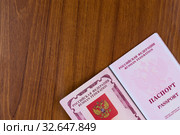 Первая страница загранпаспорта гражданина России на деревянном фоне. Стоковое фото, фотограф Павел Сапожников / Фотобанк Лори