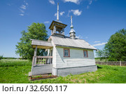 Красивая деревянная церковь со шпилем среди зеленого луга. Часовня Воздвижения Креста Господня в деревне Слобода. Россия, Архангельская область, Каргополье (2014 год). Стоковое фото, фотограф Яковлев Сергей / Фотобанк Лори
