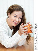 Woman with curly long hair enjoying a mug of coffee, smiling and happy girl in white sweater. Стоковое фото, фотограф Кекяляйнен Андрей / Фотобанк Лори