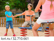 children are teetering on the swing in the playground. Стоковое фото, фотограф Яков Филимонов / Фотобанк Лори
