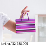 Young man with gift bag at home preparing suprise for wife. Стоковое фото, фотограф Elnur / Фотобанк Лори