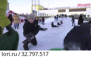 Дети катаются с ледяной горки на городской площади. Children ride on an ice slide in the town square. (2019 год). Редакционное видео, видеограф Евгений Романов / Фотобанк Лори