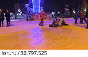 Дети катаются с ледяной горки на городской площади. Children ride on an ice slide in the town square. (2019 год). Редакционное видео, видеограф Евгений Романов / Фотобанк Лори