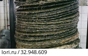 Closeup of stack of fiber mats with grinded olive paste during pressing of olive oil on artisanal factory. Стоковое видео, видеограф Яков Филимонов / Фотобанк Лори