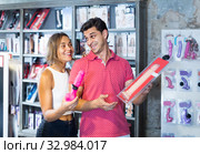 woman and man bayers choosing long rubber phallus in the sex shop. Стоковое фото, фотограф Яков Филимонов / Фотобанк Лори