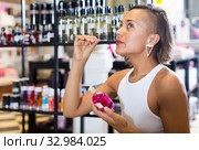 young woman choosing bottle of pheromones. Стоковое фото, фотограф Яков Филимонов / Фотобанк Лори