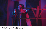 A man rapping through the pop-filter in the microphone - recording his track in the studio - music stand on the foreground. Стоковое видео, видеограф Константин Шишкин / Фотобанк Лори
