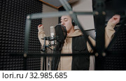 A man rapper recording his track in the studio actively gestures while the recording. Стоковое видео, видеограф Константин Шишкин / Фотобанк Лори