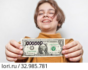 Смешная девчонка миллионерша держит доллар с приписанными шестью нолями. Стоковое фото, фотограф Элина Гаревская / Фотобанк Лори