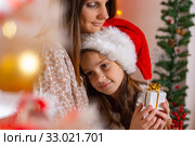 Eight-year-old daughter snuggled up to mother, in New Year's interior, close-up. Стоковое фото, фотограф Иванов Алексей / Фотобанк Лори
