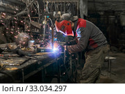 Welder works in a small workshop. Стоковое фото, фотограф Евгений Харитонов / Фотобанк Лори