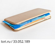Russian paper bills inside the mobile phone in the case. Стоковое фото, фотограф Элина Гаревская / Фотобанк Лори