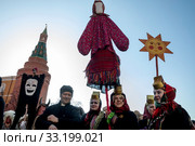 Праздничное шествие в русских национальных костюмах во время празднования Масленицы на Манежной площади на фоне башен Московского кремля в центре города Москвы в рамках фестиваля "Московская Масленица", Россия (2020 год). Редакционное фото, фотограф Николай Винокуров / Фотобанк Лори
