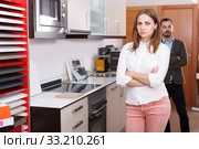 Upset girl with husband in kitchen furniture salon. Стоковое фото, фотограф Яков Филимонов / Фотобанк Лори