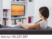 Woman Watching TV At Home. Стоковое фото, фотограф Mitar gavric / PantherMedia / Фотобанк Лори