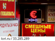 Табло обменного пункта с курсами конвертируемых валют и вывески рекламы магазинов в центре города Москвы, Россия (2020 год). Редакционное фото, фотограф Николай Винокуров / Фотобанк Лори