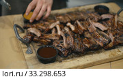Waiter cuts fried pork ribs. Стоковое видео, видеограф Kozub Vasyl / Фотобанк Лори