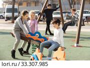 Children are teetering on the swing in the playground. Стоковое фото, фотограф Яков Филимонов / Фотобанк Лори