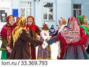 Девушки одетые в национальную старинную русскую одежду и яркие платки водят хоровод на празднике Масленицы. Город Бердск, Новосибирская область, Западная Сибирь, Россия (2020 год). Редакционное фото, фотограф Евгений Мухортов / Фотобанк Лори