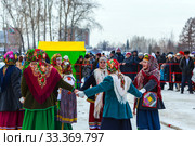 Девушки одетые в национальную старинную русскую одежду и яркие платки водят хоровод на празднике Масленицы. Город Бердск, Новосибирская область, Западная Сибирь, Россия (2020 год). Редакционное фото, фотограф Евгений Мухортов / Фотобанк Лори