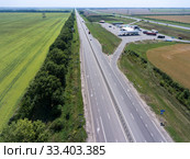 Aerial view at long straight highway with petrol station between two routes, plain terrain. Стоковое фото, фотограф Кекяляйнен Андрей / Фотобанк Лори