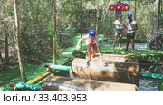 Group of excited people passing water obstacle course at adventure park. Стоковое видео, видеограф Яков Филимонов / Фотобанк Лори