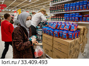 Сотрудники магазина выкладывают упаковки гречки и риса в магазине торговой сети АШАН в торговом центре МЕГА в Химках во время эпидемии ОРВИ, Россия (2020 год). Редакционное фото, фотограф Николай Винокуров / Фотобанк Лори