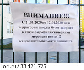 Бумажное объявление о закрытии территории школы на профилактику, вложенное в рифленый прозрачный файл и приклеенное на решетку забора (2020 год). Редакционное фото, фотограф Александр Замараев / Фотобанк Лори