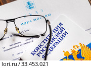 Конституция Российской Федерации и указ Мэра города Москвы N12-УМ от 5 марта 2020 года "О введении в городе режима повышенной готовности" в связи с эпидемией коронавируса COVID-19 лежит на столе. Стоковое фото, фотограф Николай Винокуров / Фотобанк Лори