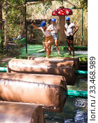 Team of friends overcomes an obstacle course in an amusement park. Стоковое фото, фотограф Яков Филимонов / Фотобанк Лори