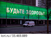 Надпись "Будьте здоровы" на огромном экране на фасаде кинотеатра "Октябрь" на Новом Арбате в центре города Москвы во время эпидемии коронавируса COVID-19 (2020 год). Редакционное фото, фотограф Николай Винокуров / Фотобанк Лори