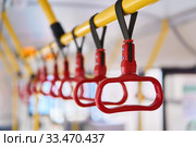 Interior elements of public transport - city bus grab handles - on a blurred background. Стоковое фото, фотограф Евгений Харитонов / Фотобанк Лори