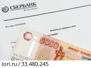 Выписка из лицевого счёта сбербанка и пачка российских денег (2019 год). Редакционное фото, фотограф Игорь Низов / Фотобанк Лори