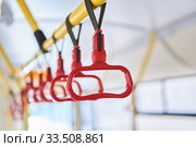 Grab handles in the passenger compartment of the bus on a blurred background. Стоковое фото, фотограф Евгений Харитонов / Фотобанк Лори