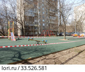 Огороженная детская площадка во дворе жилых домов в дни самоизоляции при коронавирусе Covid-19. Район Гольяново. Город Москва. Россия (2020 год). Стоковое фото, фотограф lana1501 / Фотобанк Лори