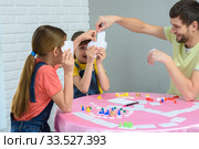 Папа вытягивает нужную карту в настольной игре с дочками. Стоковое фото, фотограф Иванов Алексей / Фотобанк Лори