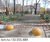 Огороженная полосатой лентой детская площадка во дворе жилых домов на Сахалинской улице в дни самоизоляции при коронавирусе Covid-19. Район Гольяново. Город Москва. Россия (2020 год). Редакционное фото, фотограф lana1501 / Фотобанк Лори