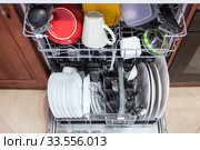 Opened dishwasher machine with clean utensil, steel spoons and cups is in the kitchen, top view. Стоковое фото, фотограф Кекяляйнен Андрей / Фотобанк Лори