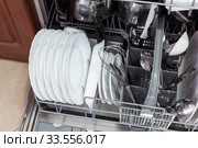 Dishwasher is loaded with utensils, clear dishes after washing. Стоковое фото, фотограф Кекяляйнен Андрей / Фотобанк Лори