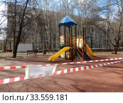 Огороженная полосатой лентой детская площадка во дворе жилых домов на Сахалинской улице в дни самоизоляции при коронавирусе Covid-19. Район Гольяново. Город Москва. Россия (2020 год). Стоковое фото, фотограф lana1501 / Фотобанк Лори
